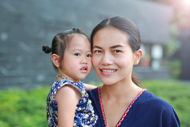 母亲和女儿的肖像在传统的宋干节服装拥抱。图片下载