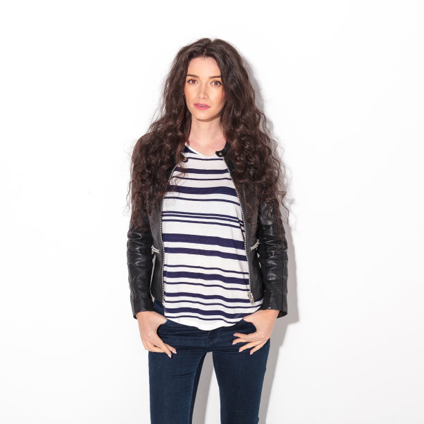 年轻的卷发女人穿着皮夹克图片下载