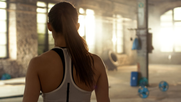 从运动美女进入健身房后拍摄。她自信，建筑是工业和硬核，各种交叉健身/健身设备躺在地板上。图片下载