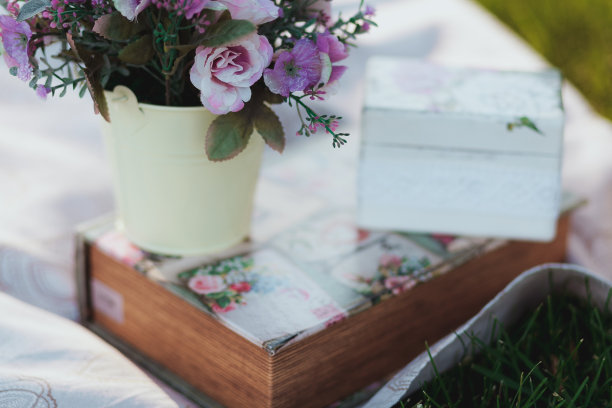 美丽的人造花在白色桌布上，以草为背景图片下载