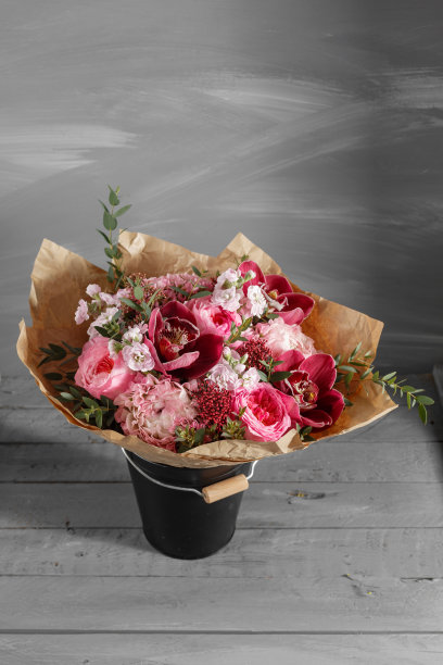 一束紫色兰花和其他颜色的花，在木背景，在篮子里。副本的空间。图片下载