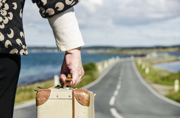 一位老妇人带着她的行李箱旅行，准备退休图片下载