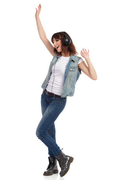 无忧无虑的年轻摇滚女孩戴着耳机跳舞和挥手图片下载