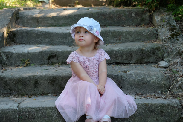 一个小女孩坐在古老的石阶上，神情恍惚图片下载