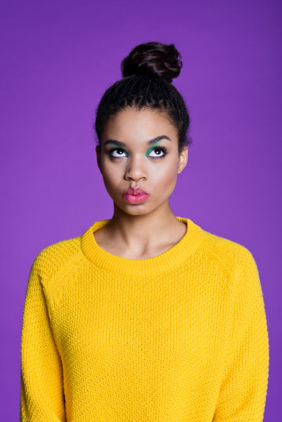 穿着黄色毛衣的可爱的美国黑人年轻女子素材图片