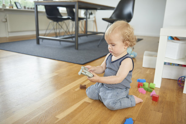 孩子侧面坐在地板上玩玩具图片下载