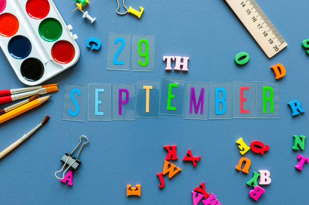 9月29日。月29日，回归学校理念。日历上有老师或学生的工作背景，蓝色的桌子上有学习用品。秋天的时间图片下载
