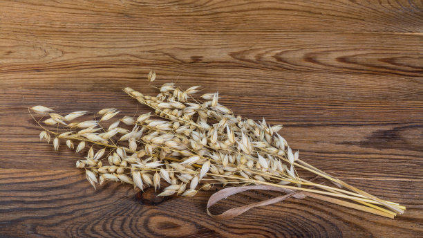 在一张木桌上，用16x9的高清比例晒干谷穗素材图片