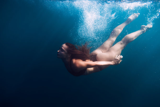 在海里游泳的女人。水下视图图片下载