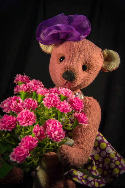 洋娃娃熊穿着裙子，手里拿着一束花图片下载