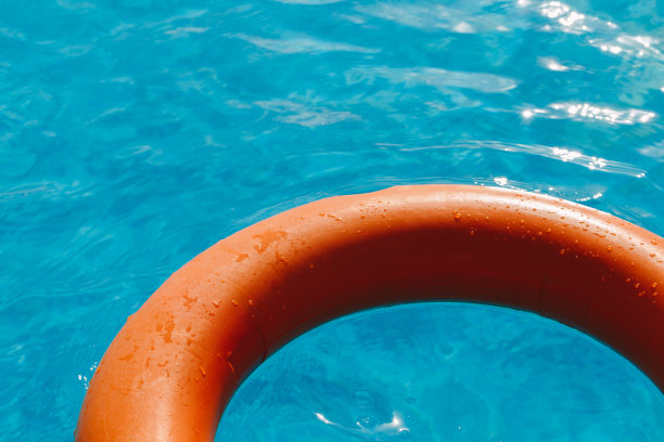 橙色救生圈在蓝色的水中图片下载