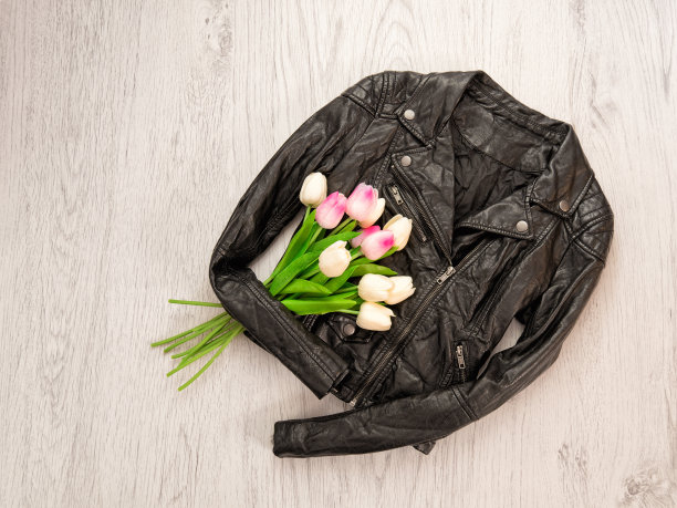 时尚的概念。黑色皮夹克，木质背景上的郁金香。俯视图图片下载