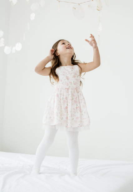 年轻美丽快乐的女孩在床上跳图片下载