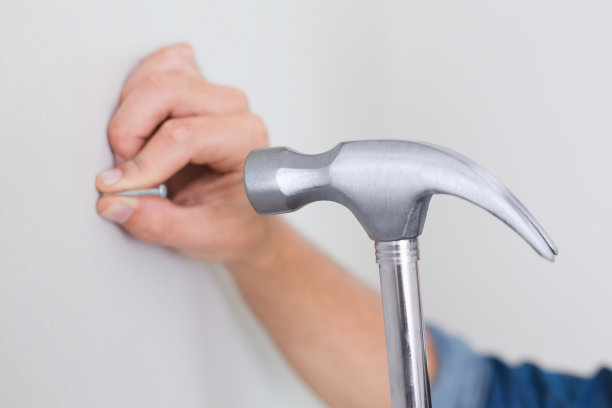 手在墙上钉钉子图片下载