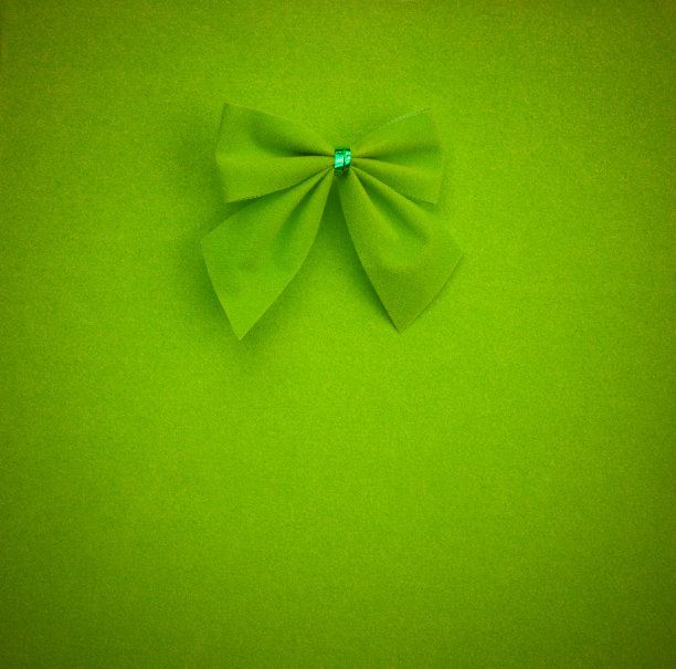 绿色的蝴蝶结，绿色的背景。模拟文本，祝贺，短语，字母图片下载