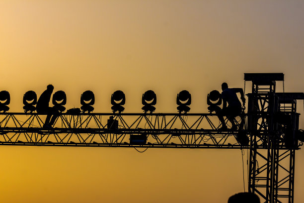 工人在音乐会的结构在夕阳的背光图片下载