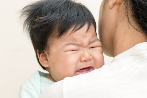 生病并在妈妈肩膀上哭泣的可爱亚洲婴儿素材图片