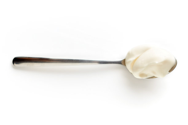 酸奶油在勺子上孤立白色，从上面图片下载