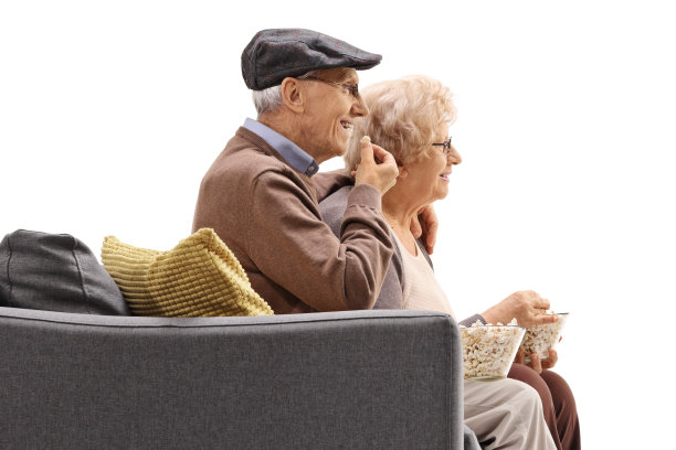 老人和女人坐在沙发上吃着爆米花图片下载