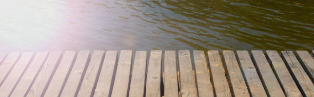 横幅复古木桌上的背景是模糊的水背景。图片下载