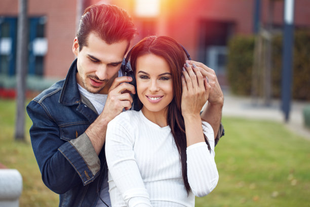 年轻夫妇通过耳机分享音乐图片下载