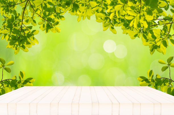 空白木桌衬绿色自然散景和绿叶框架，有文字设计或其他产品广告的复制空间。图片下载