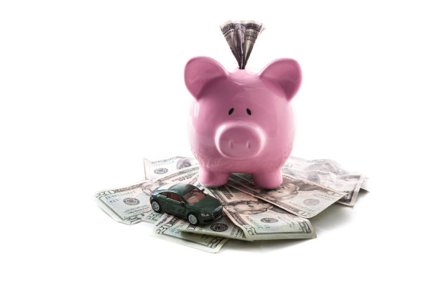 储蓄罐和玩具车放在一堆美元上图片下载