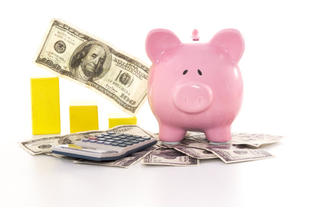 粉红色的储蓄罐旁边的图表和计算器图片下载