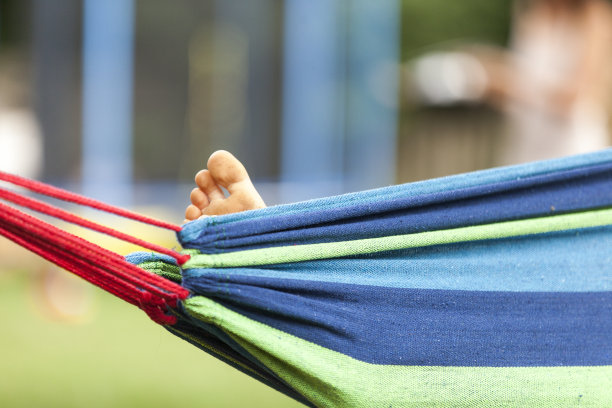 女人的脚在蓝色吊床上图片下载