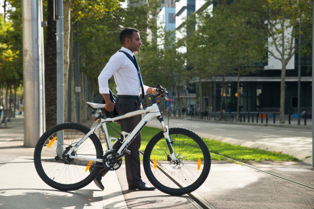 年轻的上班族骑着自行车穿过有轨电车线图片下载