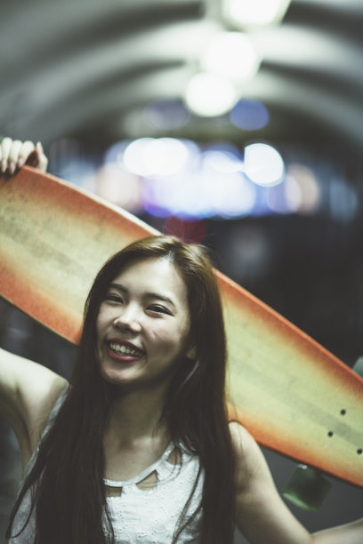 年轻女子拿着她的滑板图片下载