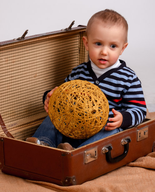 两、三岁的男婴背着一个大行李箱孤立在w上图片下载