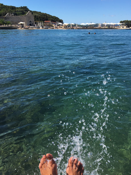 克罗地亚，在杜布罗夫尼克的科帕卡巴纳海滩上，一名女子的脚在溅水图片下载