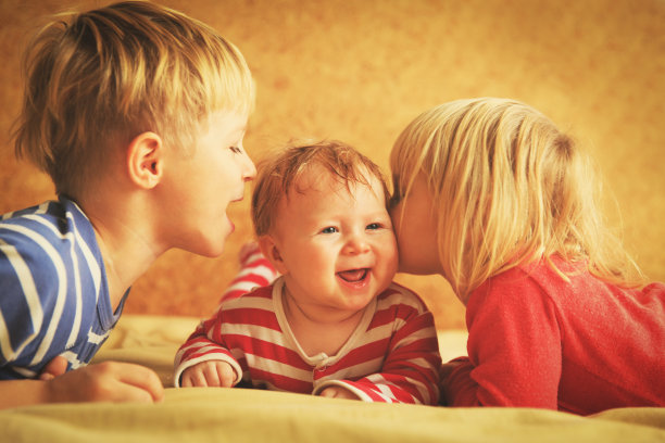 小男孩和小女孩在家里和刚出生的小妹妹玩耍图片下载