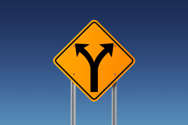 蓝色天空前面的黄色分岔路交通标志:分岔路和决策概念图片下载