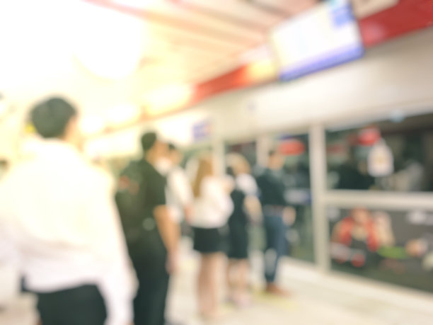 模糊人们等待各自公共交通工具的图像。图片下载