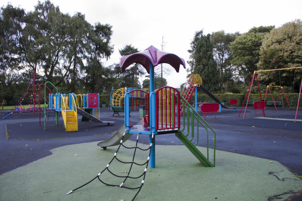 公园中央是一个空荡荡的五颜六色的儿童游乐场图片下载