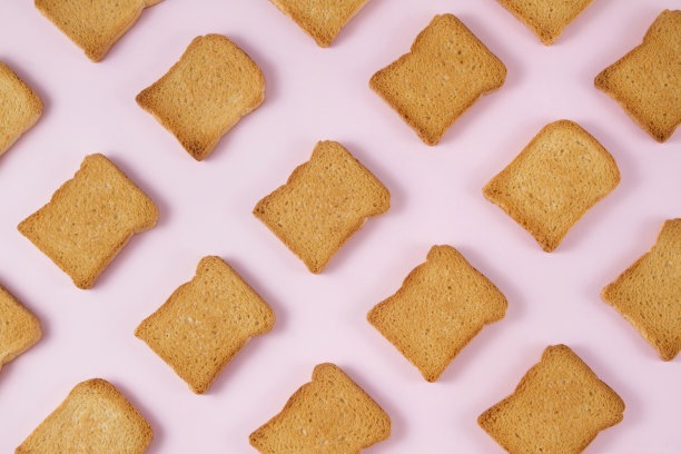 粉红色背景上的一片烤面包素材图片