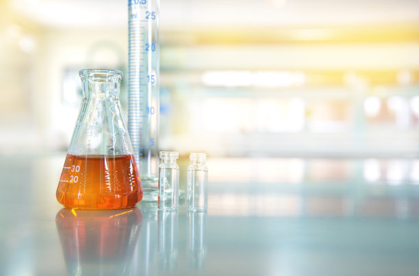 有化学实验室背景的瓶状小瓶玻璃烧瓶中的橙色液体图片下载