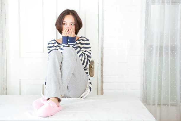 美丽的亚洲女孩坐在床上素材图片