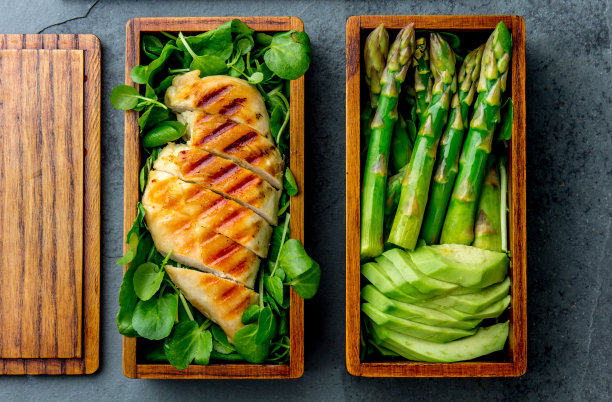 健康午餐在木制日本便当盒。营养均衡的健康食物:烤恰克、鳄梨、芦笋和蔬菜沙拉。俯视图，石板灰色背景图片下载