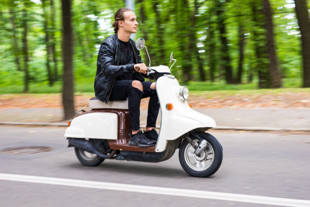 侧面的英俊男子戴眼镜骑摩托车图片下载