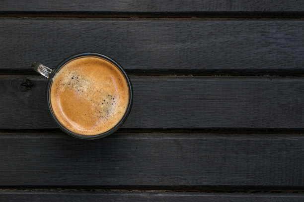 新鲜煮好的意式浓缩咖啡放在黑色木桌上，木纹、线条、图案和纹理，复制空间向右图片下载
