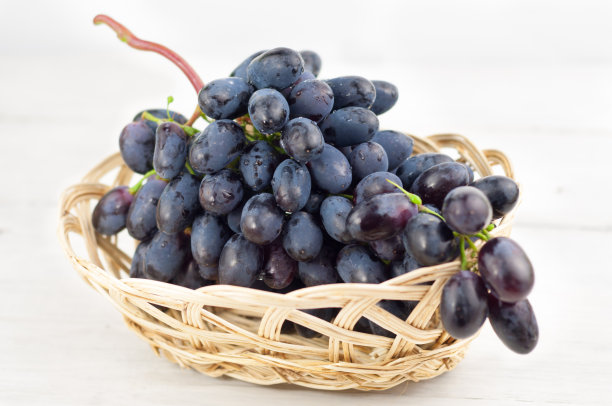 满柳条篮子的新鲜成熟的蓝葡萄在古老的木制乡村木板图片下载