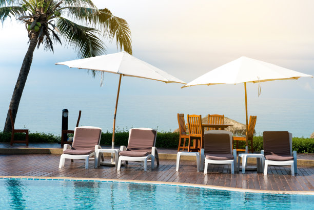 舒适的椅子在游泳池，现代的椅子，阳光上的图片，复制空间。图片下载