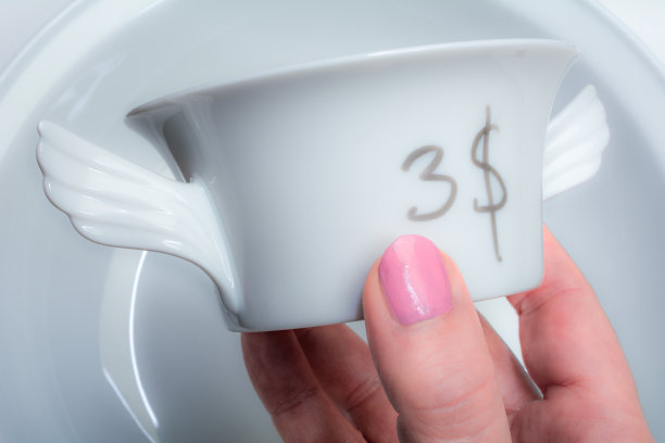 一个女人在旧货店里检查瓷杯图片下载