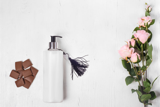 巧克力化妆品，身体霜，手霜，花在白色木质背景隔离图片下载