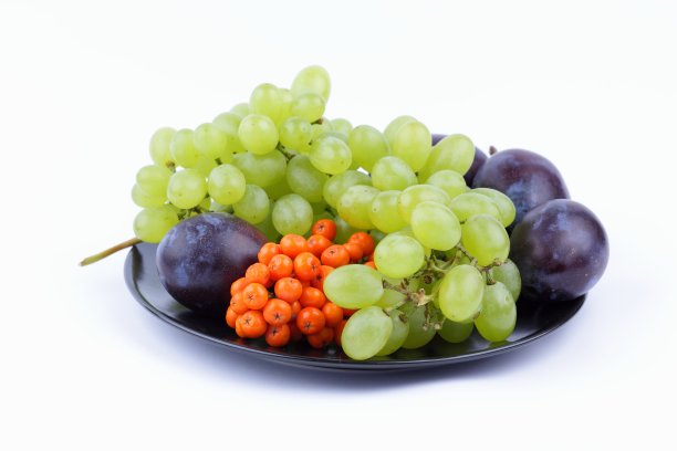 绿葡萄、花梨和大李子，白色背景，黑色盘子，极简主义风格图片下载