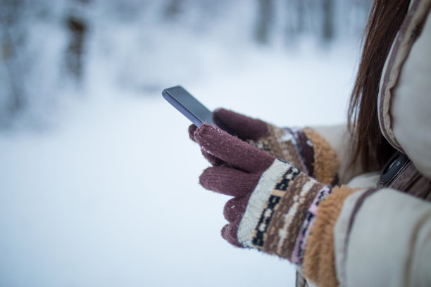 雪地里的女性手拿着手机图片下载