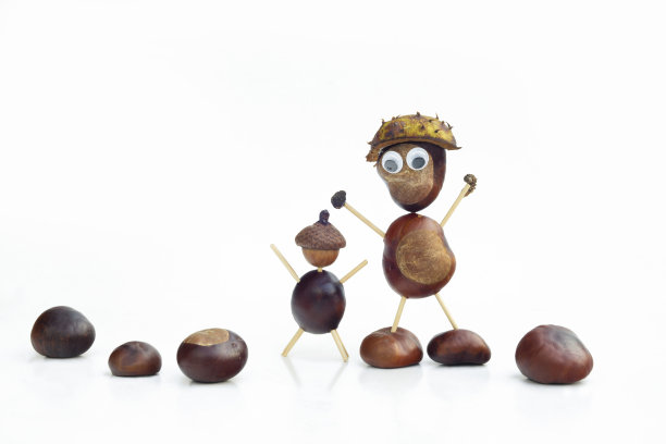 有趣的人形人物或小雕像与栗子在白色孤立的背景图片下载